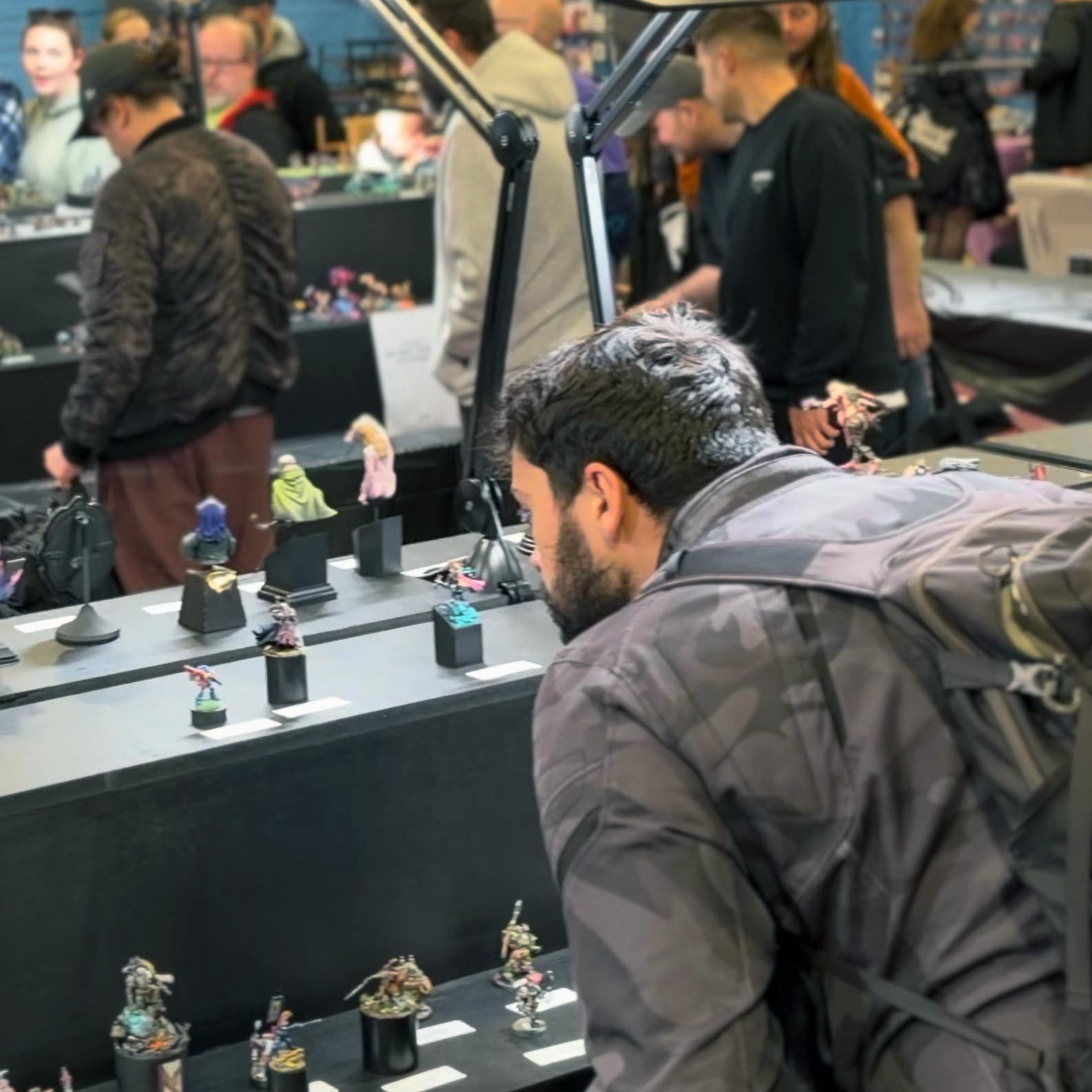 A visitor looking closely at miniatures in the display cabinets